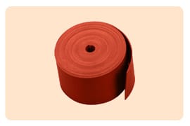 A part-unrolled reel of dull red heat shrink tape standing on end, the loose tail lying flat against the roll.