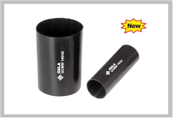 Two black heat shrink couplers of different diameters standing on end, the larger printed GALA GCMW 140/42 and the smaller GALA GCMW 70/22 along the wall